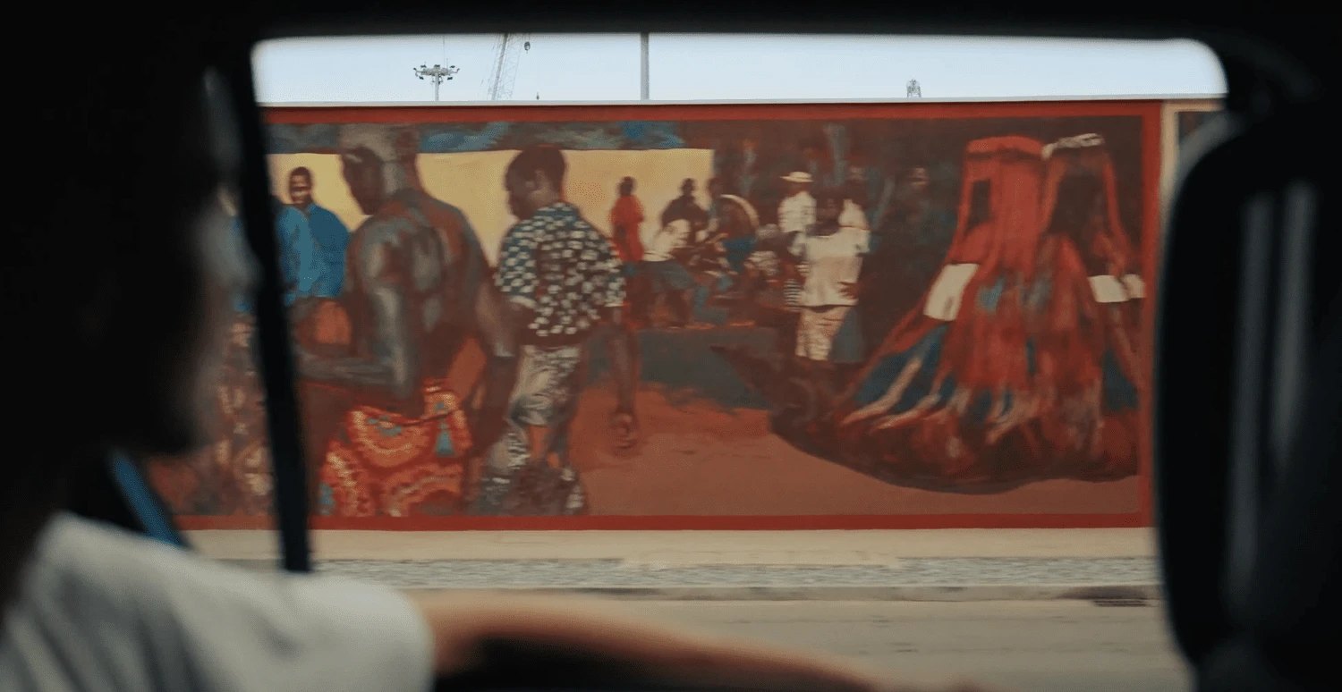 A street mural of a market crowd and Zangbeto figures, Cotonou